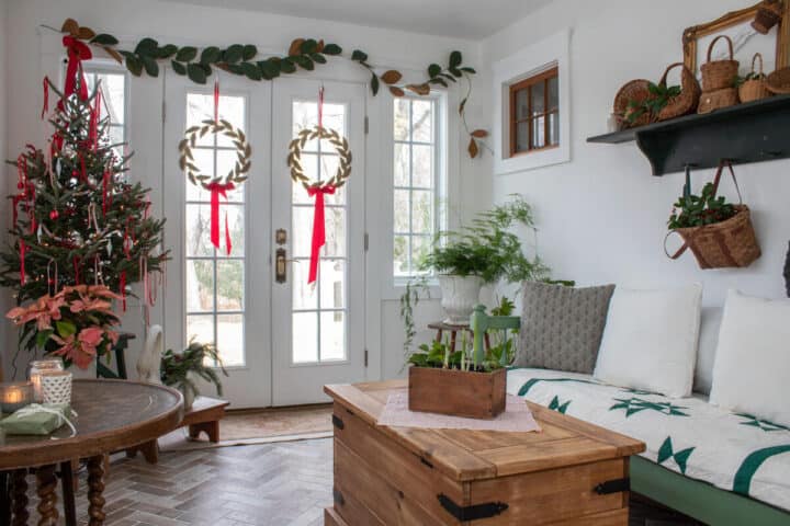 sunroom-decorated-for-Christmas-with-wreaths,-a-tree-and-magnoia-branches